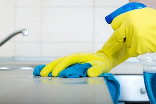 Cleaners removing builders dust from floors and skirting boards in a Kennington property